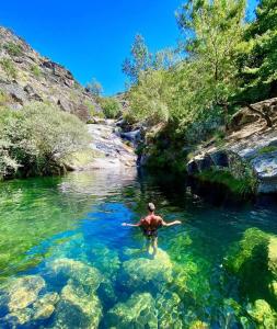 Un homme dans l'eau d'une rivière dans l'établissement Casa da Laje - Entre a Estrela e a Gardunha, à Fundão