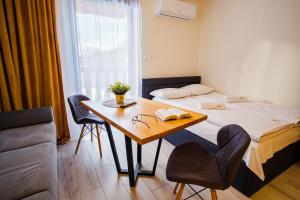 Un dormitorio con una cama y una mesa con un libro en Apartamenty Homole, en Szczawnica