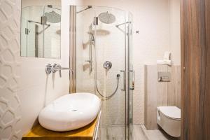 uma casa de banho com um chuveiro, um WC e um lavatório. em Apartamenty Homole em Szczawnica