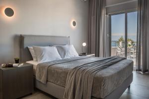 Limanaki Hotel في لاسي: غرفة نوم مع سرير وإطلالة على المحيط