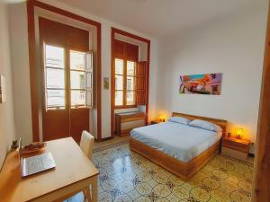 a bedroom with a bed and a desk with a laptop at Alma Canaria Apartments & Rooms in Las Palmas de Gran Canaria