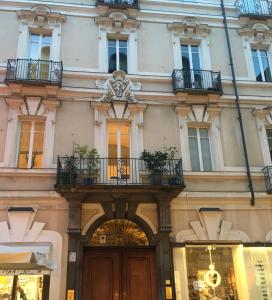 a building with a wooden door and a balcony at Via Garibaldi 31 Suites in Turin
