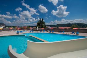 a large swimming pool with chairs and umbrellas at Chalets de Trémontagne 3 étoiles in Prénovel