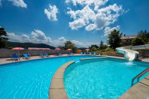 a swimming pool at a resort with chairs and umbrellas at Chalets de Trémontagne 3 étoiles in Prénovel +15 photos