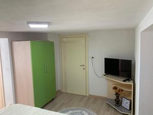 a bedroom with a green cabinet and a television at Syzo Rooftop 360° in Pogradec