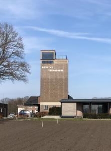 een gebouw met een bord aan de zijkant bij B&B De Silotoren in Zelhem