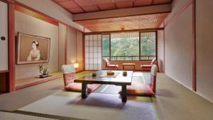 a living room with a table and chairs and a window at Mansuirou in Misasa
