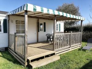 une terrasse en bois avec un auvent sur une maison dans l'établissement LE COTTAGE DE LYXIE-Nature et sports, à Talmont-Saint-Hilaire