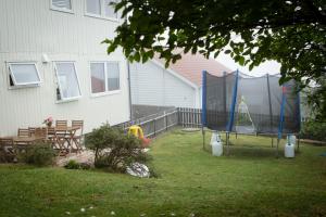 un patio trasero con columpios y parque infantil en Mørk Apartments- Great View, en Tórshavn