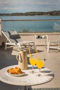 a table with two glasses of orange juice and croissants at Limanaki Hotel in Lassi