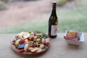 a plate of food next to a bottle of wine at Mount Ceder in Cederberg