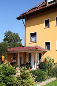 een geel huis met een rood dak bij Ferienwohnung Schmetterling in Kemmern
