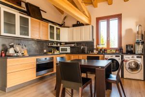 a kitchen with a table and a dining room at Relais des Roches in Sona