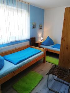 una camera con 2 letti a castello con lenzuola blu di Familie Sattler a Pappenheim