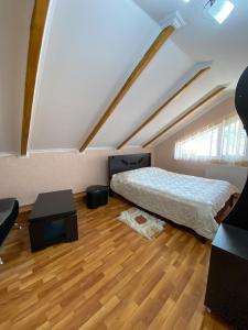 um quarto no sótão com uma cama e piso em madeira em Guest House IBERIA em Mtskheta