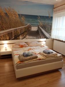 a bedroom with a bed with a painting of the ocean at Apartament CURIE - studio in Międzyzdroje