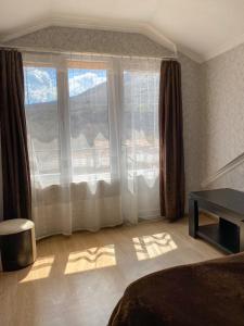 a bedroom with a bed and a large window at Guest House IBERIA in Mtskheta