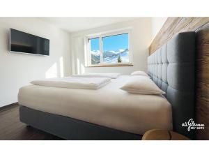 a bedroom with two beds and a window at All.Glemm SKY SUITE in Saalbach Hinterglemm