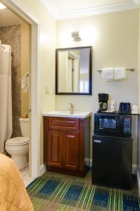 een badkamer met een wastafel, een toilet en een spiegel bij Travelodge by Wyndham by Fisherman's Wharf in San Francisco