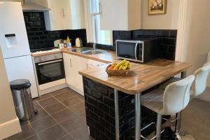 a kitchen with a table with a bowl of fruit on it at Grand 2 bed Georgian apartment at Florence House with king bed, in the heart of Herne Bay & 300m from beach in Herne Bay +22 photos