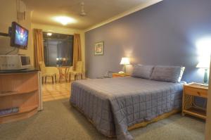 una camera d'albergo con letto e TV di Grosvenor in Cairns a Cairns