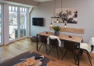 un soggiorno con tavolo e sedie in legno di Julie´s Home (Penthouse) a Niendorf