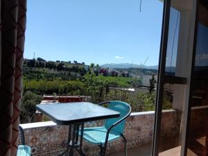 una mesa y sillas en un balcón con vistas en Taza Organic Garden with view park and restaurant, en Taza