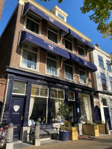 eine Ladenfront eines Gebäudes mit einer blauen Markise in der Unterkunft Hotel Bridges House - Delft City Centre in Delft + 19 Fotos