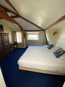 ein Schlafzimmer mit zwei Betten und einem Tisch in der Unterkunft Hotel Bridges House - Delft City Centre in Delft