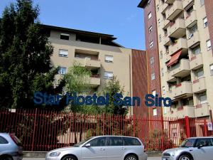 dwa samochody zaparkowane przed budynkiem w obiekcie Star Hostel San Siro Fiera w Mediolanie