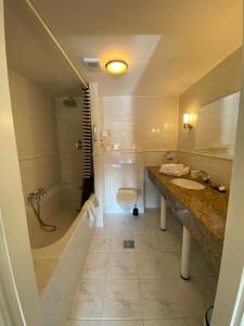 a bathroom with a tub and a toilet and a sink at Hotel Bridges House Delft in Delft