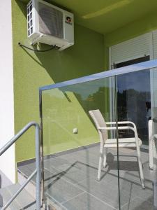 balcone con sedia e condizionatore d'aria di Apartmani Matko a Nin