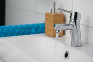 a bathroom sink with water coming out of a faucet at Vakantiehuis op Villapark Oesterbaai aan zee , met speeltuin grenzend aan de tuin in Wemeldinge +39 photos