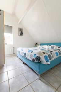 a bedroom with a bed and a tile floor at Vakantiehuis op Villapark Oesterbaai aan zee , met speeltuin grenzend aan de tuin in Wemeldinge