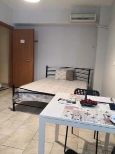 1 dormitorio con cama, mesa, mesa y sillas en House in the center of Piraeus next to the port and the metro!!, en Pireo