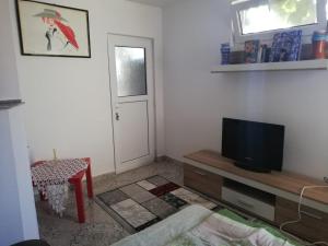 a living room with a television and a table at Casa Ana in Eforie Sud