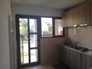 a kitchen with a window and a sink and a stove at Casa Ana in Eforie Sud
