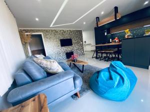 a living room with a blue couch and a table at Aqua Blue Lakeview Apartment Ohrid in Peštani