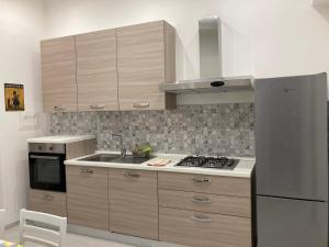 a kitchen with wooden cabinets and a stove top oven at Il filo di Jordi in Savona +9 photos