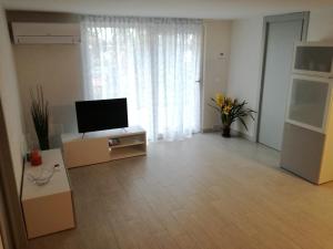a living room with a flat screen tv on a cabinet at Appartamento Le Ancore in Marciana Marina