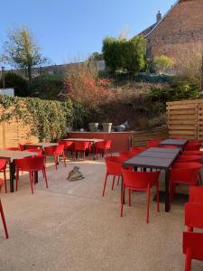 a group of tables and chairs with red chairs at Entre Nous in Rozoy-sur-Serre