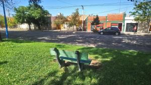 a green park bench sitting in the grass at Dpto PREMA in General Roca