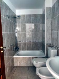 Vivienda Vacacional Helios - Penthouse Deluxe في تازاكورتي: حمام مع حوض ومرحاض ومغسلة