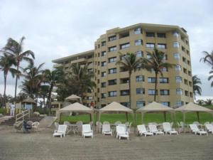 a group of chairs and umbrellas in front of a building at Mayan Vidanta departamento 2 recámaras CON SERVICIO DE PLAYA in Acapulco