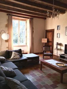a living room with a couch and a table at "La Maison de Villars" au coeur de la nature in Pressac