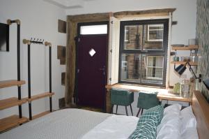 Schlafzimmer mit einem Bett, einem Fenster und einer Tür in der Unterkunft Grooms House in Hebden Bridge