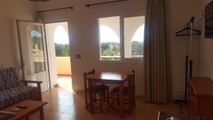 a living room with a table and two windows at Villa Clementina in Es Pujols