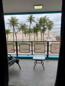 een kamer met uitzicht op een strand met palmbomen bij Santa Helena Pousada in Guarujá