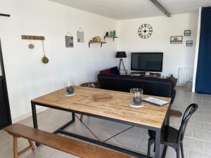 sala de estar con mesa y sofá en La Commanderie des Templiers Gîte 4 étoiles, en Saint-Étienne-de-Brillouet