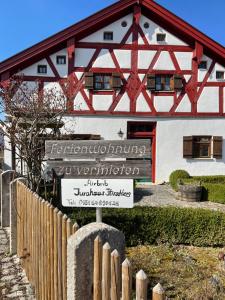 a sign in front of a building with a wooden roof at Jurahaus Hirschberg in Beilngries